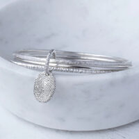 A photo of the KS03 - Triple Hammered Bangle With Fingerprint Charm Memorial from G. Seller